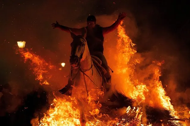 A man rides a horse through a bonfire during “Las Luminarias” Festival on January 16, 2017 in San Bartolome de Pinares, Spain. (Photo by Pablo Blazquez Dominguez/Getty Images)