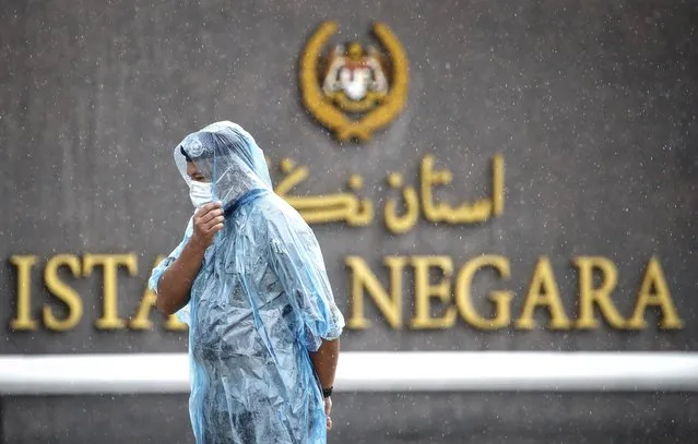 Police stand guard in the rain at the main entrance of the National Palace in Kuala Lumpur, Malaysia, Friday, August 20, 2021. Malaysian state royals are meeting Friday at the national palace to discuss the appointment of a new prime minister, with the likely choice stirring public anger and warnings of more political instability. (Photo by F.L. Wong/AP Photo)
