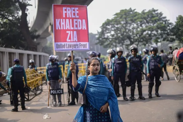 A woman holds a placard as supporters of Bangladesh Nationalist Party (BNP) form a human chain marking International Human Rights Day in Dhaka, Bangladesh, Sunday, December 10, 2023. The opposition allege that thousands of their activists have been detained by security agencies ahead of the country's general election on Jan. 7. The BNP, led by former Prime Minister Khaleda Zia, is boycotting the election leaving voters in the South Asian nation of 166 million with little choice but to re-elect Prime Minister Sheikh Hasina's Awami League for a fourth consecutive term. (Photo by Mahmud Hossain Opu/AP Photo)