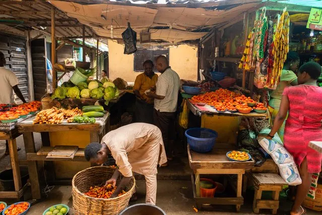 People buy and sell food at the Illaje market, in Bariga, Lagos, on June 29, 2021. Since the start of the pandemic in 2019, food prices have risen by an average of more than 22%, according to official statistics, and feeding a family properly has become a daily challenge. (Photo by Benson Ibeabuchi/AFP Photo)
