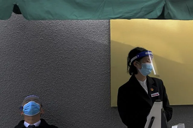Workers wearing face masks and shields to help curb the spread of the coronavirus wait for visitors outside a museum in Beijing, Thursday, October 28, 2021. (Photo by Andy Wong/AP Photo)
