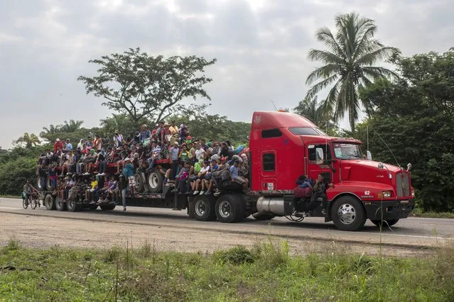 Migrants are transported on the bed of a trailer in Jesus Carranza, in the Mexican state of Veracruz, Wednesday, November 17, 2021. A group of mainly Central American migrants are attempting to reach the U.S.-Mexico border. (Photo by Felix Marquez/AP Photo)