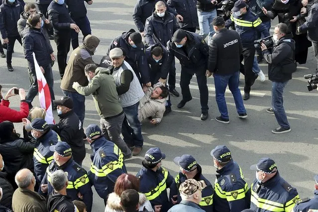 Police detain a supporter of former Georgian President Mikheil Saakashvili, who was convicted in absentia of abuse of power during his presidency and arrested upon his return from exile, at a court building during a court hearing in Tbilisi, Georgia, Monday, November 29, 2021. Saakashvili, who was president from 2008-13, left Georgia after the end of his second term and was later convicted in absentia of abuse of power. He was arrested on Oct. 1 after returning to Georgia to try to bolster opposition forces in the run-up to nationwide municipal elections. (Photo by AP Photo/Stringer)