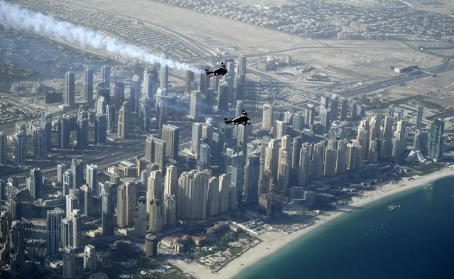 An aerial view taken from behind airplane's window glass shows Swiss pilot and aviation enthusiast Yves Rossy(Bottom) known as the Jetman and French Vince Reffett (Up) flying over Jumeirah Beach Residence (also known as JBR)  in Dubai, United Arab Emirates on 12 May 2015. (Photo by Ali Haider/EPA)