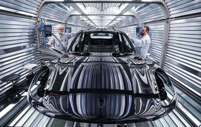 Workers assemble a Porsche Macan model on the production and quality control line of the Porsche plant on the eve of the company's annual general meeting in Leipzig, eastern Germany, March 11, 2024. (Photo by Ronny Hartmann/AFP Photo)