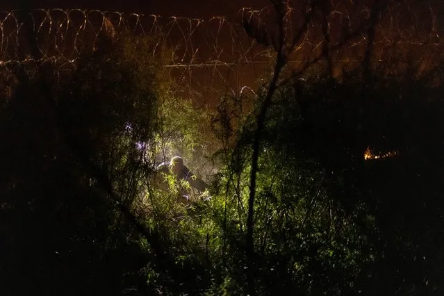 A Texas State Trooper surveys part of the razor wire-laden fence, erected to deter migrants after it was breached earlier along the bank of the Rio Grande river, in El Paso, Texas on March 28, 2024. (Photo by Adrees Latif/Reuters)