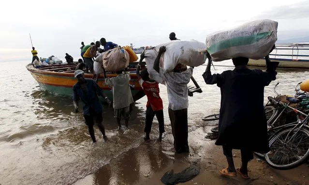 Burundian refugees carry their belongings as they board a boat on the shores of Lake Tanganyika in Kagunga village in Kigoma region in western Tanzania to Kigoma township, May 17, 2015. (Photo by Thomas Mukoya/Reuters)
