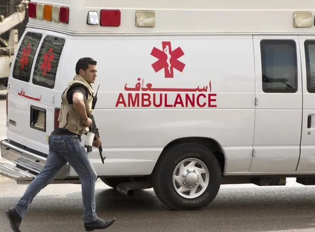 An armed security personnel escorts an ambulance carrying ousted former Egyptian President Hosni Mubarak into a helicopter ambulance from Maadi Military Hospital, where he is hospitalized, to be taken to the Cairo Police Academy--turned--court, in Cairo, Egypt, Thursday, March 2, 2017. Mubarak is standing retrial in charges of complicity in the killings of protesters during 2011 Egyptian uprising. (Photo by Amr Nabil/AP Photo)