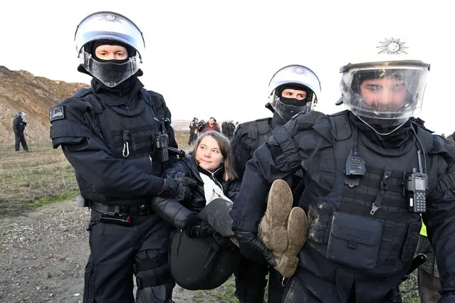 Police officers carry Swedish climate activist Greta Thunberg away from the edge of the Garzweiler II opencast lignite mine during a protest action by climate activists after the clearance of Luetzerath, Germany, Tuesday, January 17, 2023. After the eviction of Luetzerath ended on Sunday, coal opponents continued their protests on Tuesday at several locations in North Rhine-Westphalia. (Photo by Roberto Pfeil/dpa via AP Photo)