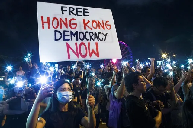 Demonstrators wave their smartphones during a rally ahead of the G20 summit, urging the international community to back their demands for the government to withdraw a the extradition bill in Hong Kong, China on June 26, 2019. Thousands of people in Hong Kong joined an evening protest and marched to major foreign consulates urging leaders gathering for this week's G20 summit to back their demand to scrap a much criticized extradition bill. (Photo by Thomas Peter/Reuters)