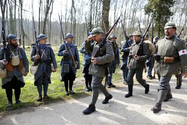 Members of a German World War I historical association, front, march past members of French association Le Poilu de la Marne as they leave the village of Bezonvaux. (Photo by Charles Platiau/Reuters)