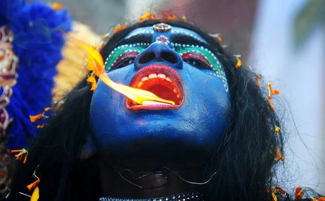 An Indian artist dressed as the Hindu goddess Kali participates in a procession to celebrate the Ram Navami festival in Allahabad on April 8, 2014. Hindu devotees celebrate the festival of Ram Navami, the birth anniversary of Lord Rama, across India, which also marks the end of the nine-day long fasting and Navaratri festival. (Photo by Sanjay Kanojia/AFP Photo)