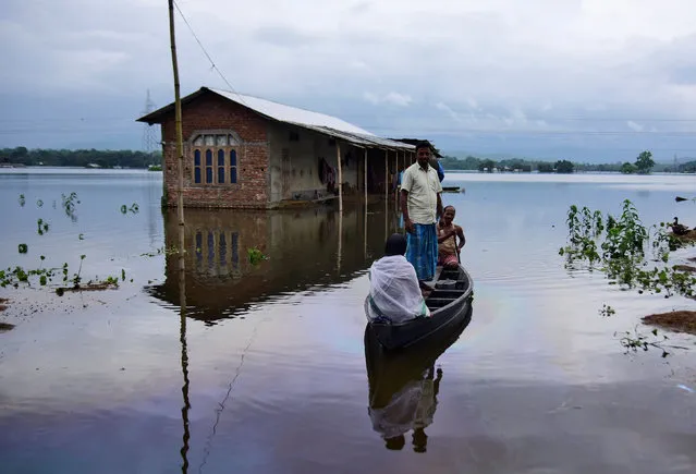 Villagers are transported on a boat towards a safer place at a flooded village in Nagaon district, in the northeastern state of Assam, India on July 15, 2019. (Photo by Anuwar Hazarika/Reuters)