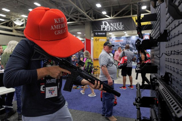 Danny Batsalkin holds a rifle during the annual National Rifle Association (NRA) meeting in Dallas, Texas, U.S., May 18, 2024. (Photo by Shelby Tauber/Reuters)