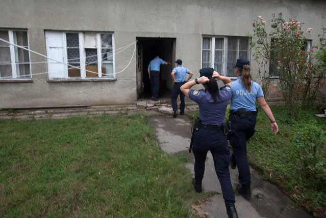 Police enter the house where a suspect killed six people, including a ten-year-old child, before committing suicide, in Zagreb, Croatia, Friday, August 2, 2019. Croatian police identified the killings Friday as domestic violence. (Photo by Nikola Solic/AP Photo)