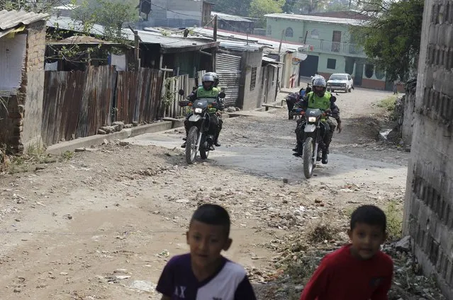 Members of the Military Police for Public Order (PMOP) patrol the impoverished Flor del Campo neighbourhood in Tegucigalpa, Honduras, April 29, 2015. Since taking office in January 2014, Honduras' President Juan Orlando Hernandez has delegated the intelligence and counternarcotics operations to the military, creating the Military Police for Public Order. (Photo by Jorge Cabrera/Reuters)