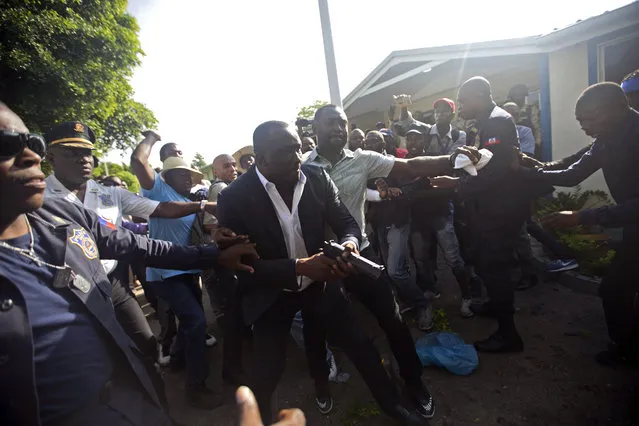 Ruling party Senator Willot Joseph holds a gun as he arrives for a vote on the ratification of Fritz William Michel's nomination as prime minister in Port-au-Prince, Haiti, Monday, September 23, 2019. (Photo by Dieu Nalio Chery/AP Photo)