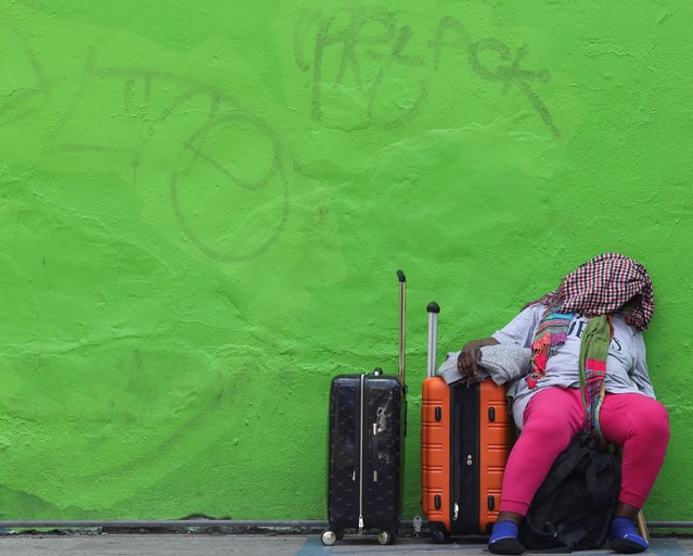 A woman waits at a FlixBus bus stop in New York City on July 2, 2024. (Photo by Kent J Edwards/Reuters)