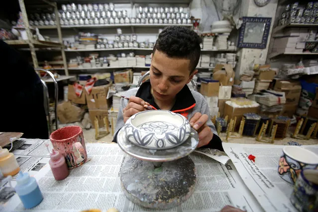 A Palestinian boy paints ceramics in Al-Okhowa pottery shop in the West Bank city of Hebron February 9, 2017. (Photo by Mussa Qawasma/Reuters)