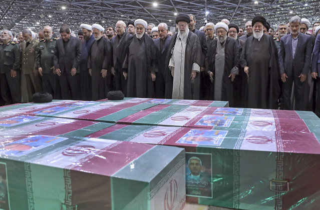 In this photo released by the office of the Iranian supreme leader, Supreme Leader Ayatollah Ali Khamenei, center right with black turban, leads a prayer over the flag-draped coffins of the late President Ebrahim Raisi and his companions who were killed in a helicopter crash on Sunday in a mountainous region of the country's northwest, at the Tehran University campus, during a funeral ceremony for them in Tehran, Iran, Wednesday, May 22, 2024. (Photo by Office of the Iranian Supreme Leader via AP Photo)