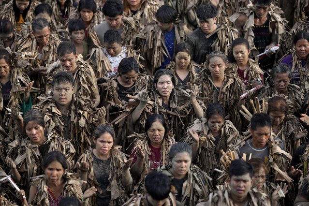 Devout Catholics, dressed in dried banana leaves, participate in mass at the church of Saint John the Baptist during the mud festival at Bibiclat, Nueva Ecija province, northern Philippines, Monday, June 24, 2024. (Photo by Aaron Favila/AP Photo)