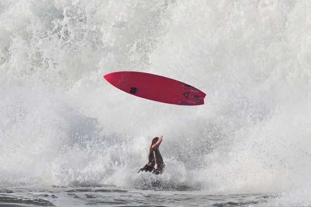 A surfer falls while competing during the Itacoatiara Big Wave 2024 at Itacoatiara beach in Niteroi, RÌo de Janeiro state, Brazil, on August 14 , 2024. (Photo by Pablo Porciuncula/AFP Photo)