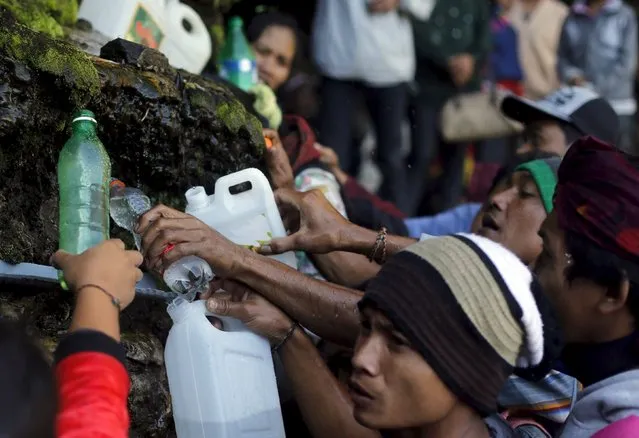 Hindu villagers collect holy water from a stream for prayers ahead of the annual Kasada festival at Mount Bromo in Indonesia's East Java province, July 31, 2015. (Photo by Reuters/Beawiharta)