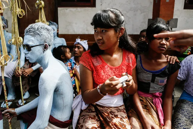 Young members of the village community wait the Grebeg Ritual begin on June 25, 2014 in Tegallalang Village, Gianyar, Bali, Indonesia. During the biannual ritual, young members of the community parade through the village with painted faces and bodies to ward off evil spirits. (Photo by Putu Sayoga/Getty Images)