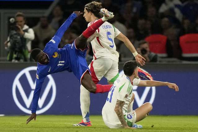 France's Ousmane Dembele falls to the ground in a clash with Italy's Riccardo Calafiori and Alessandro Bastoni, right, during the UEFA Nations League soccer match between France and Italy at the Parc des Princes in Paris, Friday, September 6, 2024. (Photo by Michel Euler/AP Photo)