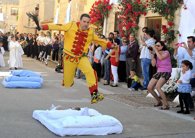 A man representing the devil leaps over babies during the festival of El Salto del Colacho (the devil's jump) on June 22, 2014 in Castrillo de Murcia, Spain. The festival, held on the first Sunday after Corpus Cristi, is a catholic rite of the devil cleansing babies of original sin. (Photo by Denis Doyle/Getty Images)