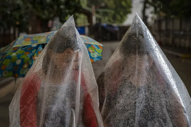 Residents use plastic bags to shield themselves from ash mixed with rainwater as Taal Volcano erupts on January 12, 2020 in Talisay, Batangas province, Philippines. Local authorities have begun evacuating residents near Taal Volcano as it began spewing ash up to a kilometer high Sunday afternoon. The Philippine Institute of of Volcanology and Seismology has raised the alert level to three out of five, warning of the volcano's continued “magmatic unrest”. (Photo by Ezra Acayan/Getty Images)