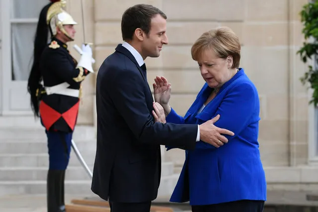 German Chancellor Angela Merkel (R) is welcomed by French President Emmanuel Macron upon her arrival at the Elysee Palace in Paris, France, 13 July 2017. (Photo by Julien de Rosa/EPA)