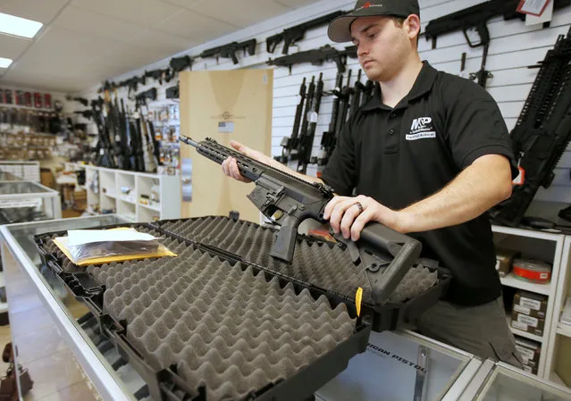 Salesman, Ryan Martinez  takes an AR-10 out of it's case at the “Ready Gunner” gun store in Provo, Utah, U.S., June 21, 2016. (Photo by George Frey/Reuters)