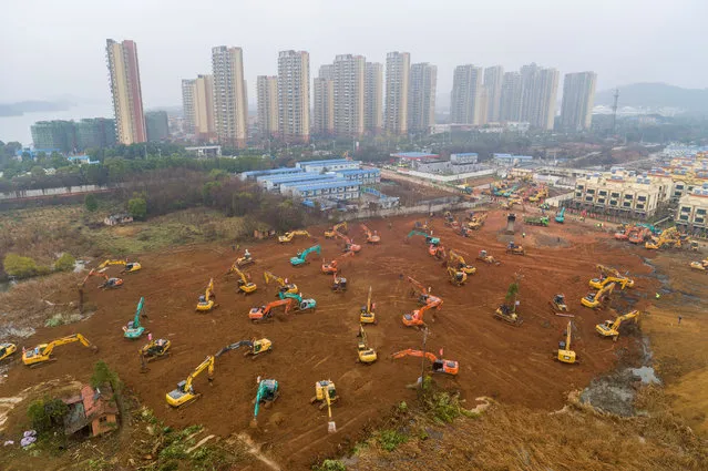 Heavy equipment works at a construction site for a field hospital in Wuhan in central China's Hubei Province, Friday, January 24, 2020. China is swiftly building a 1,000-bed hospital dedicated to patients infected with a new virus that has killed 26 people, sickened hundreds and prompted unprecedented lockdowns of cities during the country's most important holiday. (Photo by Chinatopix via AP Photo)