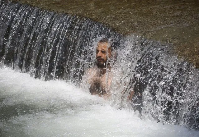 A Kashmiri man cools himself under a waterfall to beat the heat on a hot day on the outskirts of Srinagar, the summer capital of Indian Kashmir, 04 July 2022. Kashmir is witnessing hot weather conditions for the past couple of days. (Photo by Farooq Khan/EPA/EFE/Rex Features/Shutterstock)