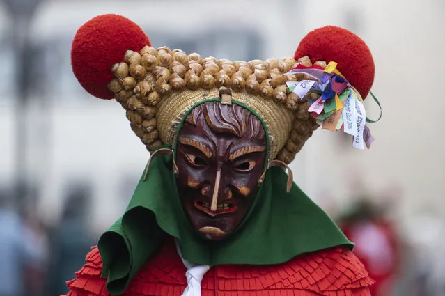 A fool of the Elzacher Schuttig walks through the main street during the traditional Schuttig jump carnival parade in Elzach, Germany, Sunday, February 23, 2020. (Photo by Patrick Seeger/dpa via AP Photo)