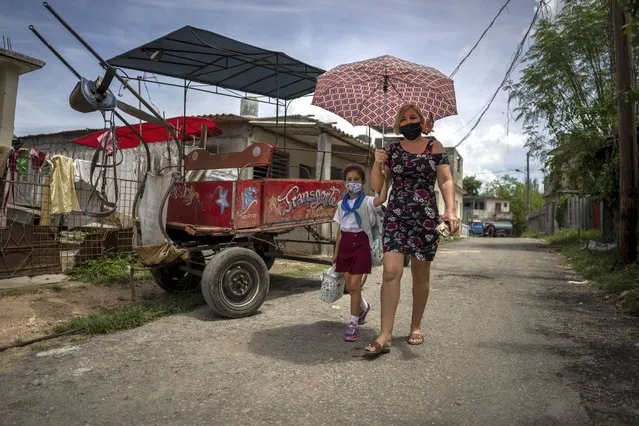 Danmara Triana walks home after picking up her daughter Alice from school in Cienfuegos, Cuba, Thursday, May 19, 2022. Triana's husband and son, who is Alice's father and brother, have lived in the U.S. since 2015, while she and their two daughters stayed behind. (Photo by Ramon Espinosa/AP Photo)