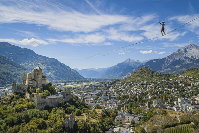 A picture taken with a drone shows Swiss slackliner Yannick Wieser walking on a 300 meter-long slackline between the castles of Valere and Tourbillon, during the “Gravit'High” event in Sion, Switzerland, 07 September 2024. (Photo by Valentin Flauraud/EPA)