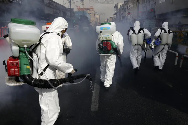 Firefighters disinfect a street against the new coronavirus, in western Tehran, Iran, Friday, March 13, 2020. The new coronavirus outbreak has reached Iran's top officials, with its senior vice president, Cabinet ministers, members of parliament, Revolutionary Guard members and Health Ministry officials among those infected. The vast majority of people recover from the new coronavirus. According to the World Health Organization, most people recover in about two to six weeks, depending on the severity of the illness. (Photo by Vahid Salemi/AP Photo)