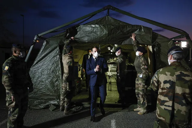 French President Emmanuel Macron wears a face mask during his visit at the military field hospital in Mulhouse, eastern France, Wednesday, March 25, 2020. French President Emmanuel Macron launched a special military operation Wednesday to help fight the new virus in one of the world's hardest-hit countries. (Photo by Mathieu Cugnot/Pool via AP Photo)