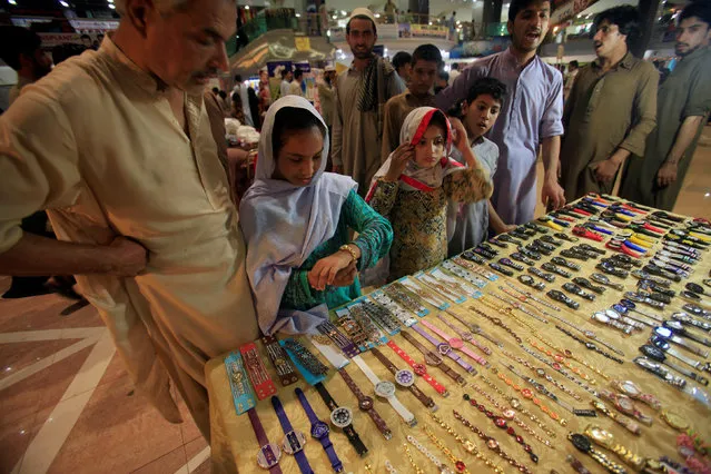 Children select watches at a stall in the Saddar Bazar ahead of Eid al-Fitr, which marks the end of the Muslim holy fasting month of Ramadan, in Peshawar, Pakistan June 5 2016. (Photo by Fayaz Aziz/Reuters)