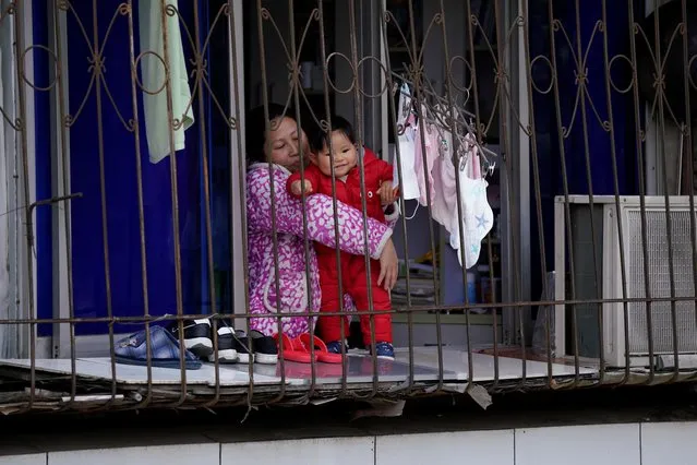 A woman and a baby are seen at a window of a blocked residential community in Wuhan, Hubei province, the epicentre of China's coronavirus disease (COVID-19) outbreak, April 1, 2020. (Photo by Aly Song/Reuters)