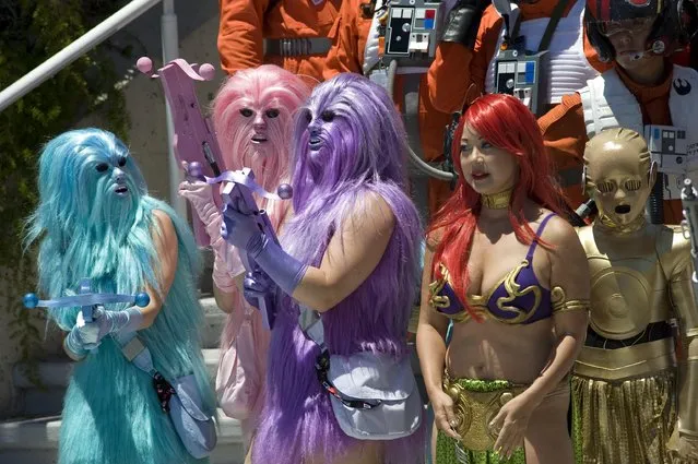 Convention goers dressed as bright colored Wookiees (L), a fictional species from the Star Wars universe, join other cosplayers as they prepare for a group photo outside Comic Con 2016 in San Diego, California, USA, 22 July 2016. (Photo by David Maung/EPA)