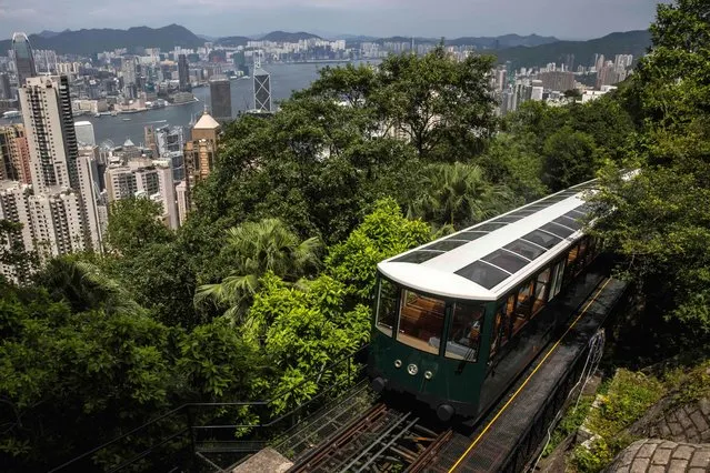 The Peak Tram is seen in front of the Hong Kong skyline on August 24, 2022, during a media tour to unveil the newly renovated sixth generation Peak Tram at a cost of 799 million HKD (102 million USD). (Photo by Isaac Lawrence/AFP Photo)