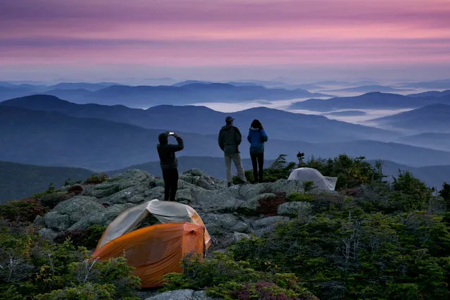 Robert Weiss of Tewksbury, Mass., left, photographs his brother-in-law, Matthew Ferri, of Dracut, Mass., and his wife, Andrea Weiss just before sunrise from their campsite on the Appalachian Trail in Beans Purchase, N.H., Sunday, September 17, 2017. The backpackers were taking advantage of pleasant weather to get in some hiking on the final weekend of summer. (Photo by Robert F. Bukaty/AP Photo)