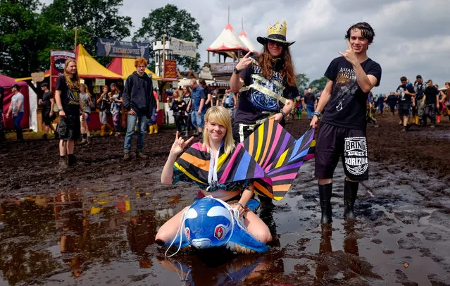 Metal fans pose on the muddy grounds of the Wacken Open Air, in Wacken, Germany, 04 August 2016. The W:O:A festival is the world's largest heavy metal music event and runs until 06 August. (Photo by Axel Heimken/EPA)