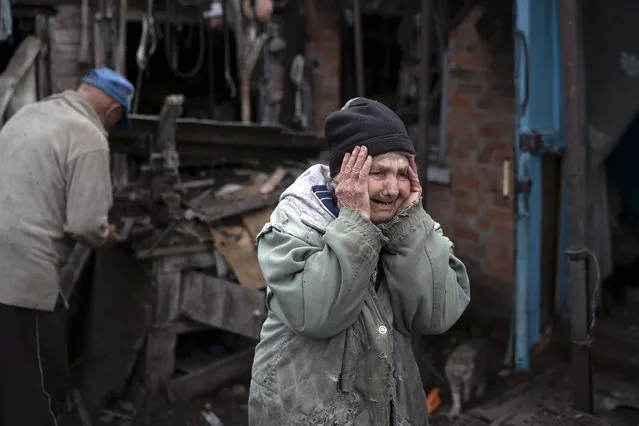 Valentina Bondarenko reacts as she stands with her husband Leonid outside their house that was heavily damaged after a Russian attack in Sloviansk, Ukraine, Tuesday, September 27, 2022. The 78-year-old woman was at garden and fell on the ground at the moment of the explosion. “Everything flew and I started to run away”, says Valentina. (Photo by Leo Correa/AP Photo)