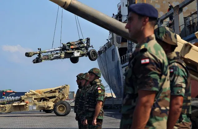 Lebanese troops stand guard near a ship as weapons from the United States are unloaded at Beirut's port in Lebanon, Tuesday, August 9, 2016. The U.S. supplied the Lebanese army with new military assistance, the latest in supplies given over the past years. The U.S. delivered an entire ship full of military equipment, including vehicles, ammunition and artillery pieces. (Photo by Bilal Hussein/AP Photo)
