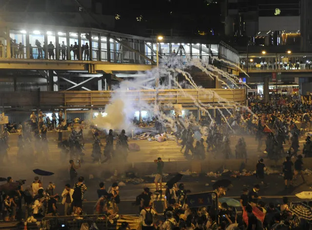 Riot police fire teargas to disperse protesters, after thousands of protesters blocked the main street to the financial Central district outside the government headquarters in Hong Kong September 28, 2014. (Photo by Reuters/Stringer)
