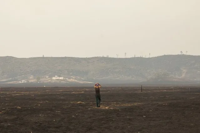 Robert Hooper, exhausted after several days with little sleep, is pictured on his property that was burnt by the so-called Valley Fire near Middleton, California September 14, 2015. (Photo by David Ryder/Reuters)